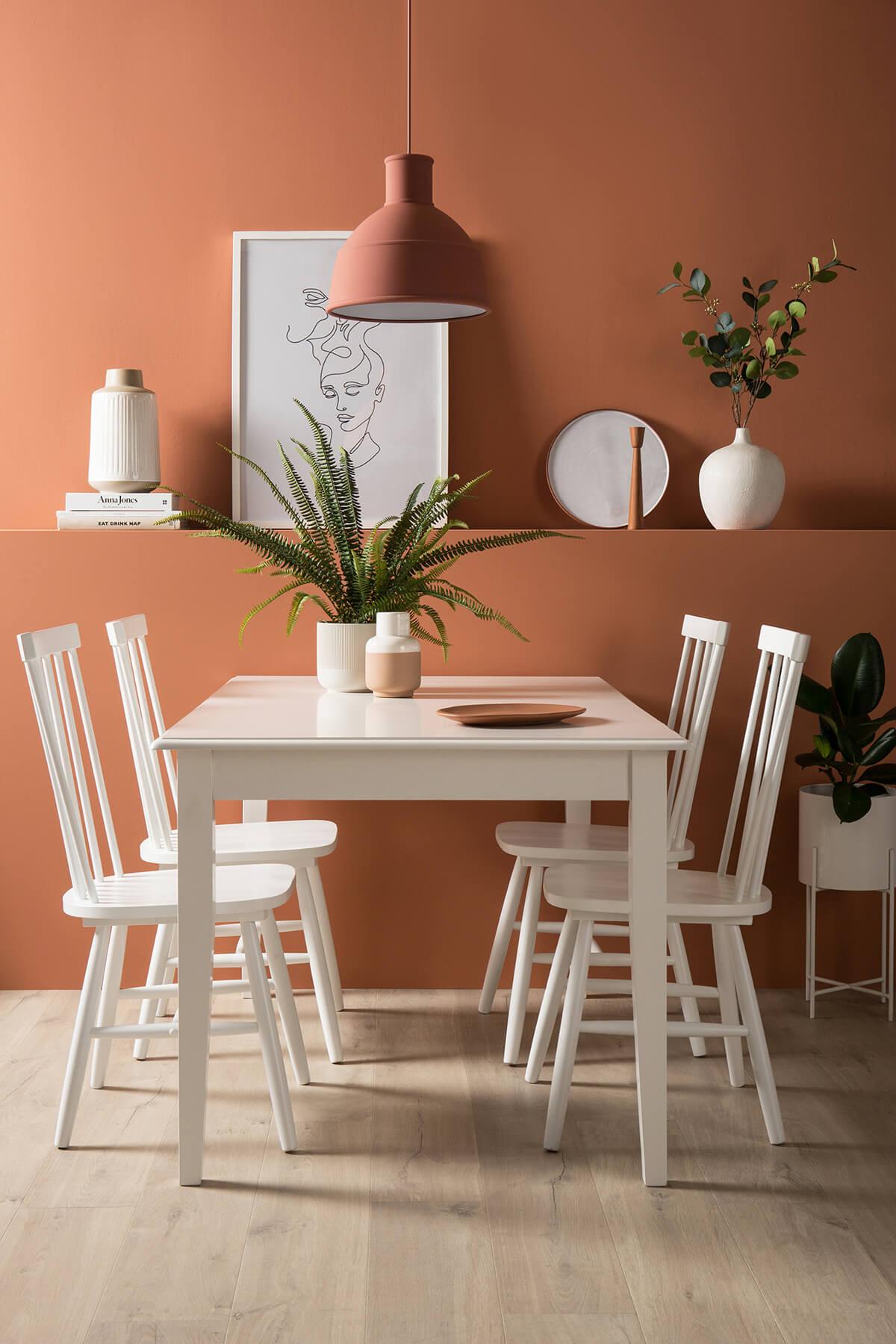 Nordic design inspired dining room with canyon clay walls and white dining set.