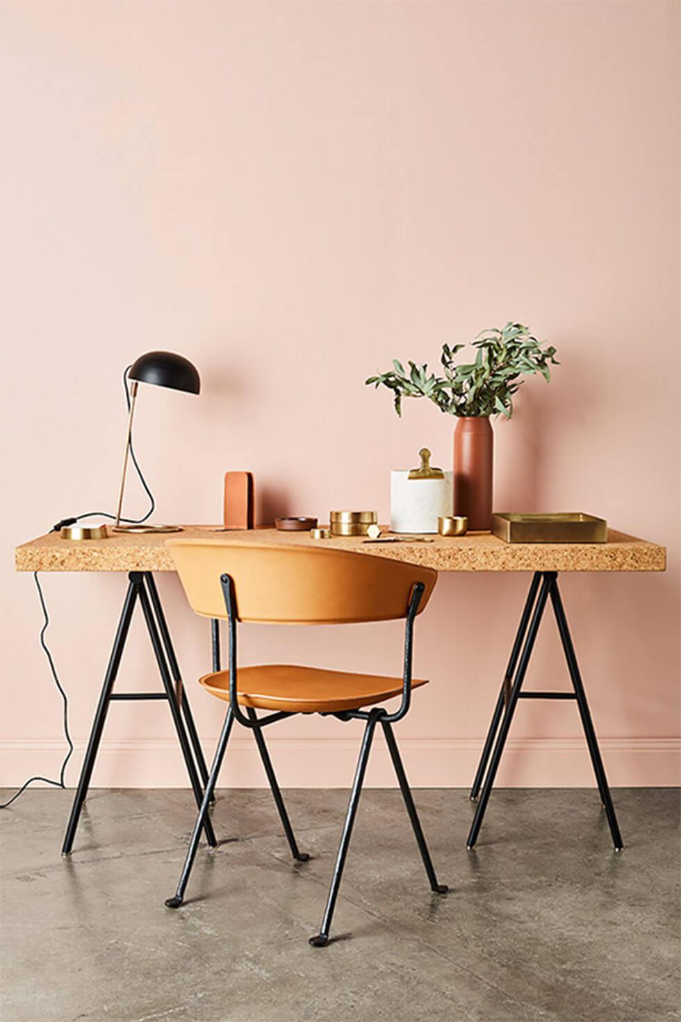 Nordic design inspired home office with dusty pink walls, wooden chair and desk with brass accents.