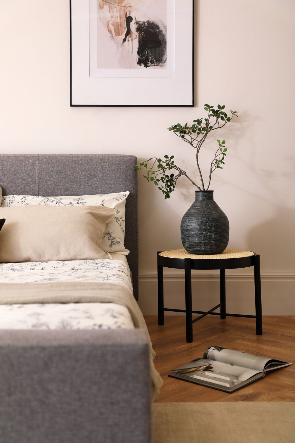 Grey fabric bed and potted plant in a Japandi bedroom