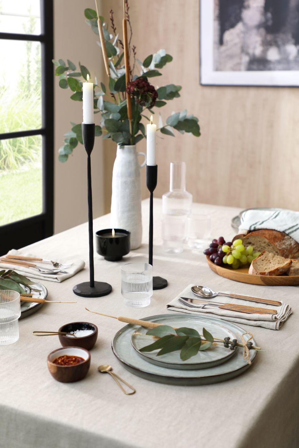 Japandi style dining table with ceramic dinnerware and a plant centrepiece