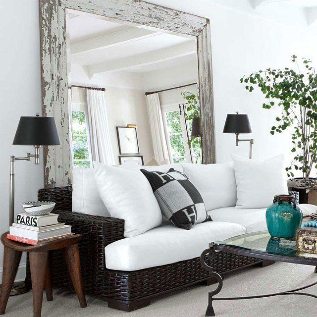 White living room with black sofa and large mirror