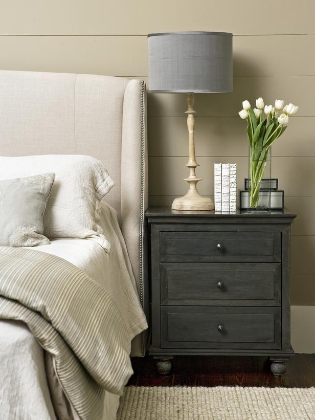 Dark grey side table with grey lamp and white flowers.