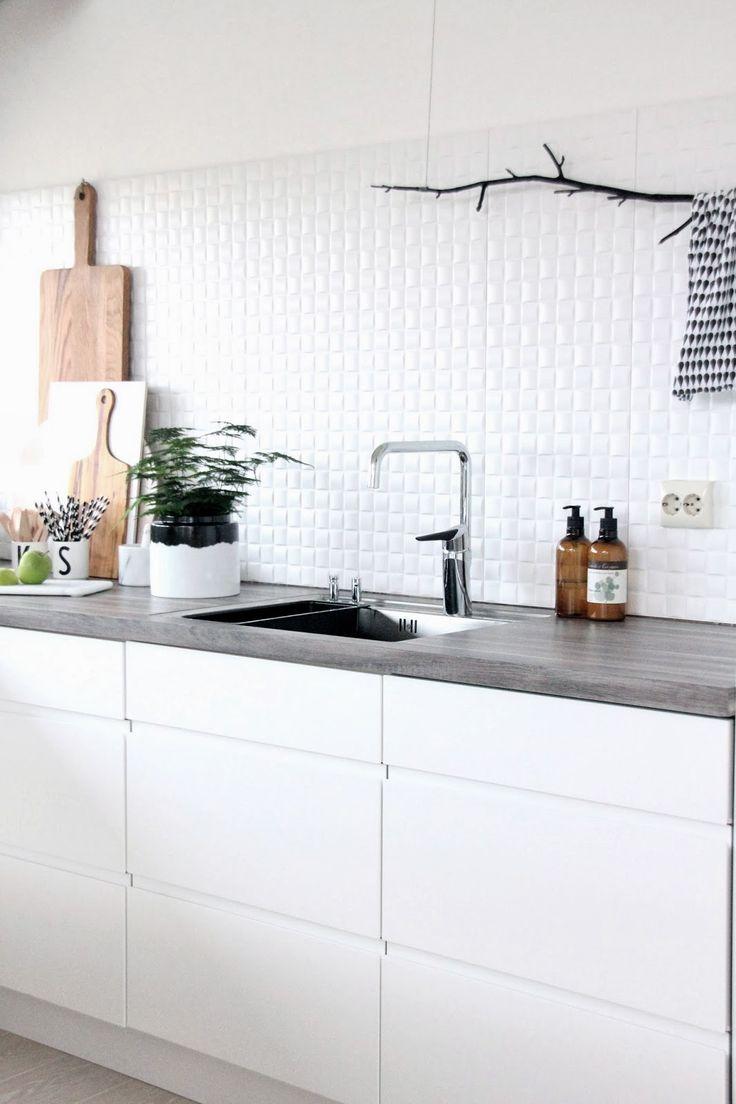 White kitchen with grey countertop and tiled walls