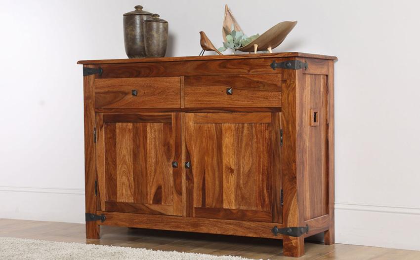 A wooden cabinet with ornaments on top.