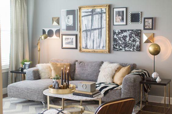 Large grey sofa, pink and white pillows, framed photos on the wall.