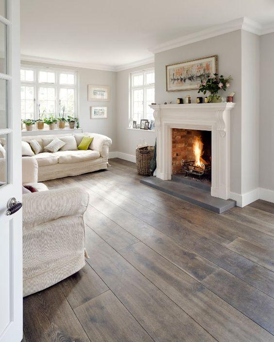 White living room with wooden floors and a fireplace. 