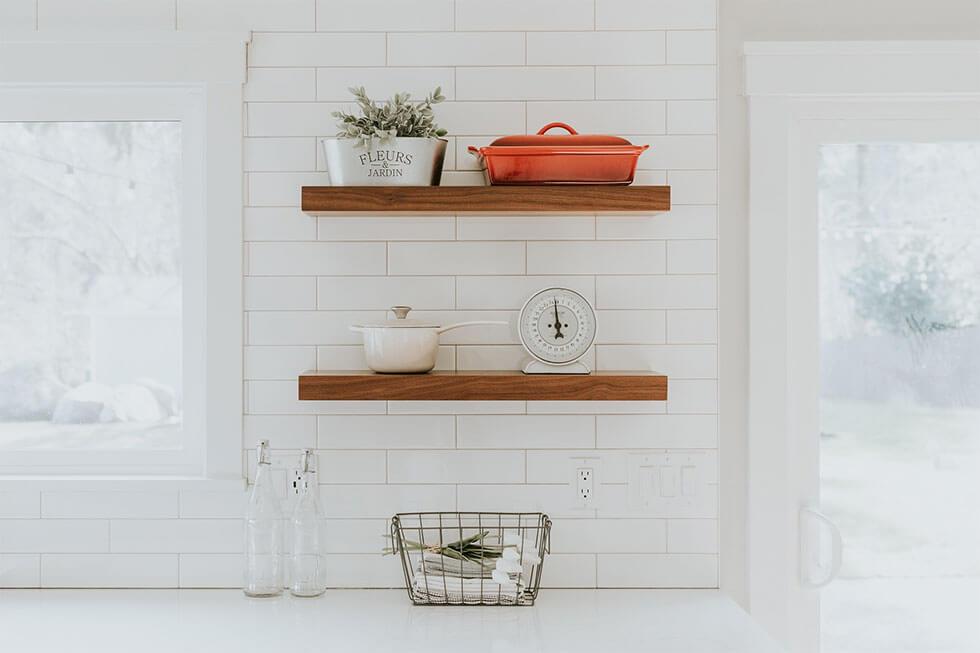 Wooden kitchen shelves with Le Creuset cookware.