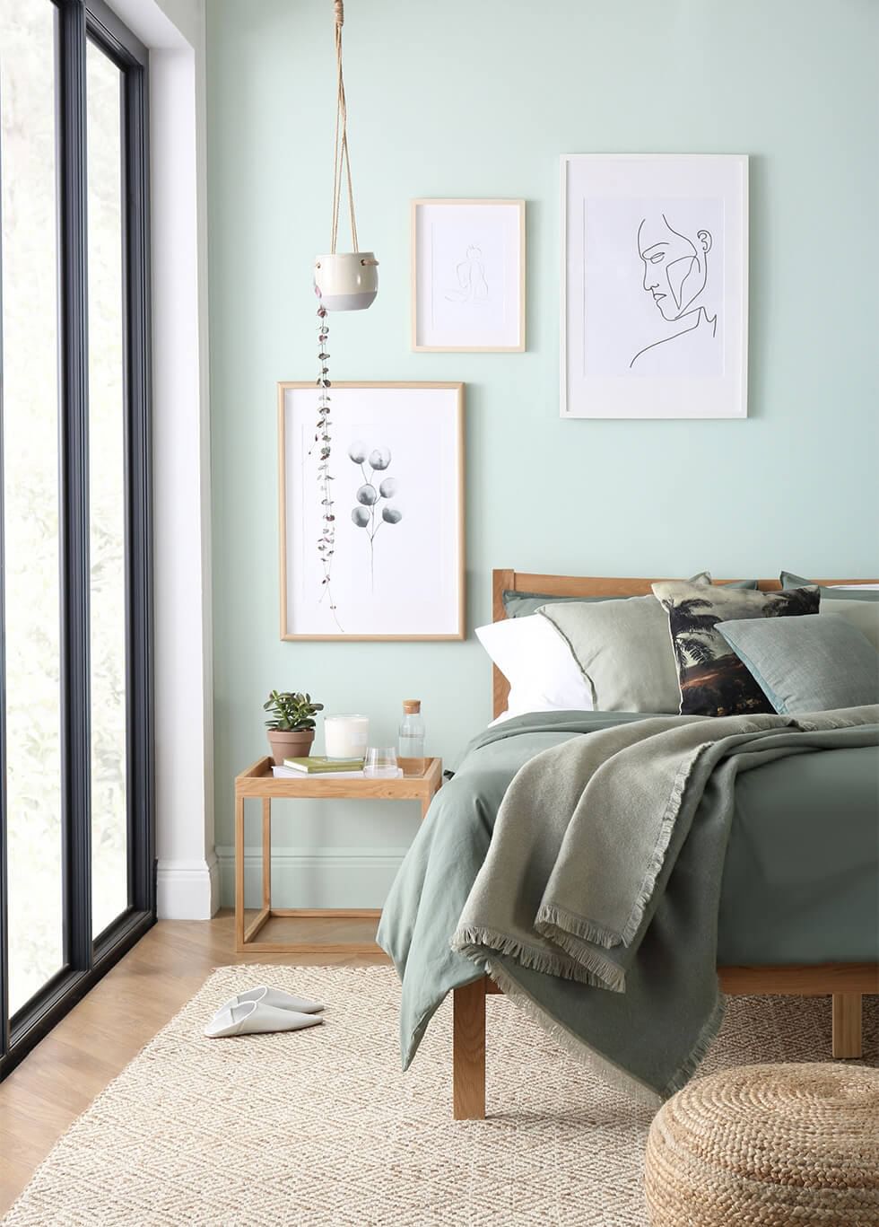 Light green minimalist bedroom with lots of natural lighting