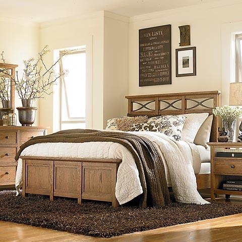 Country bedroom with wooden bed and white flowers.