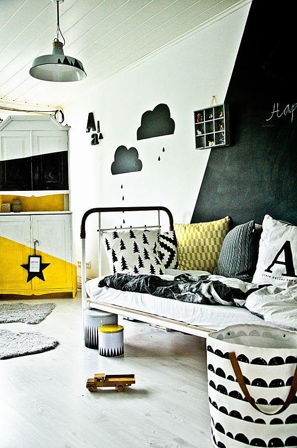 Bedroom with graphic black and white rain cloud decals, and other monochrome prints, with pops of yellow