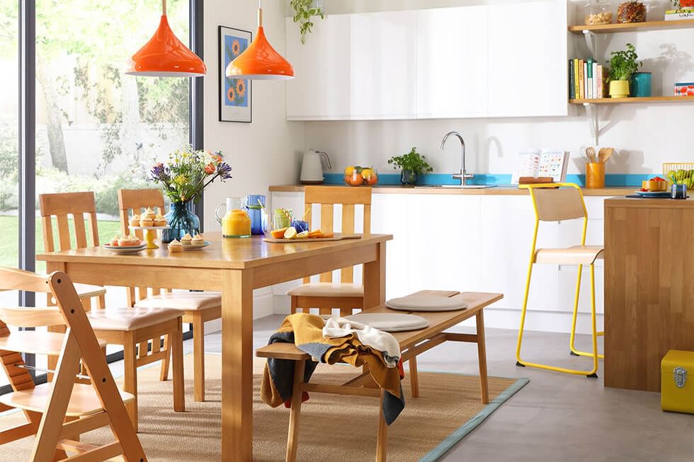 Wooden dining table and matching chairs in open plan kitchen