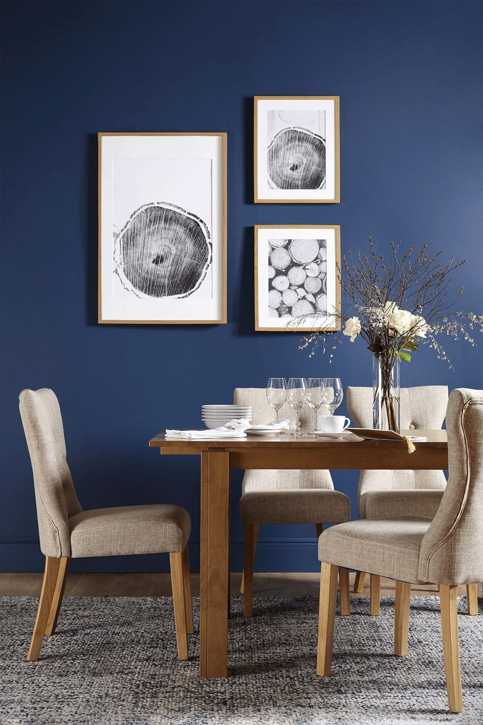 A dark grey rug under an oak dining set