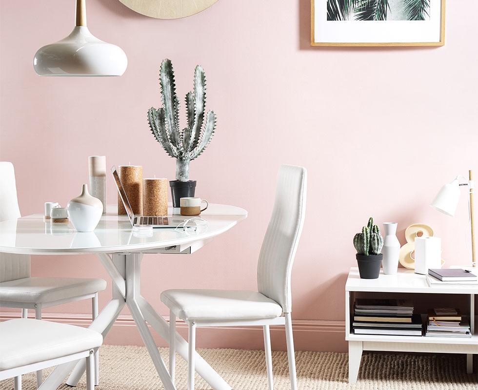 White dining set in a pink room.