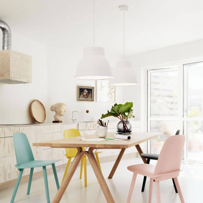 An airy dining room with pastel dining chairs.