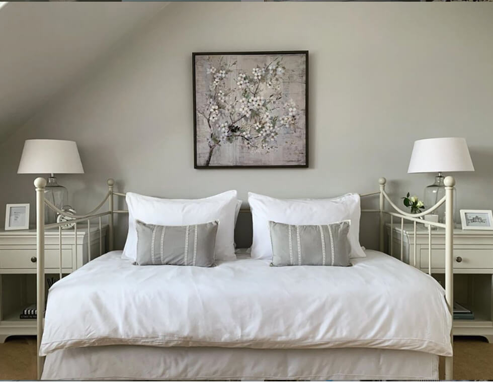 Cosy neutral bedroom with white bedding and grey walls