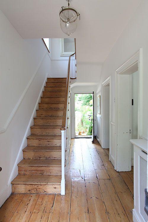 White hallway with wooden stairs. 