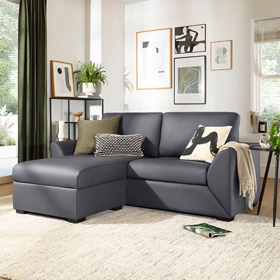 Dark grey L-shaped corner sofa with leather upholstery in modern living room