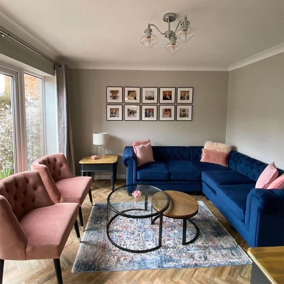 Living room with a blue corner sofa and pink armchairs
