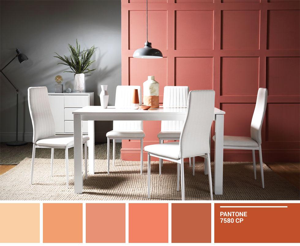 A white dining set against a terracotta and grey wall.