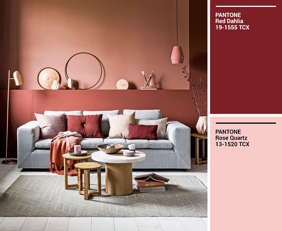 A living room with a pale sofa set against a terracotta wall, with pink and orange accents. 