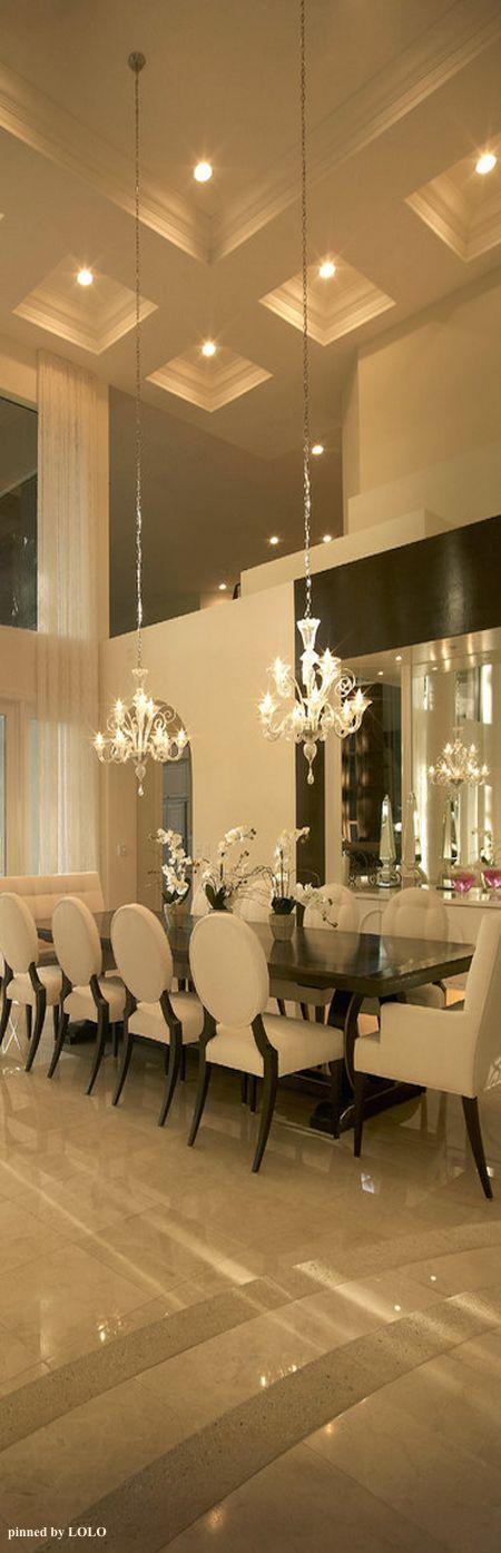 Dining arrangement with a white centrepiece and two chandeliers. 