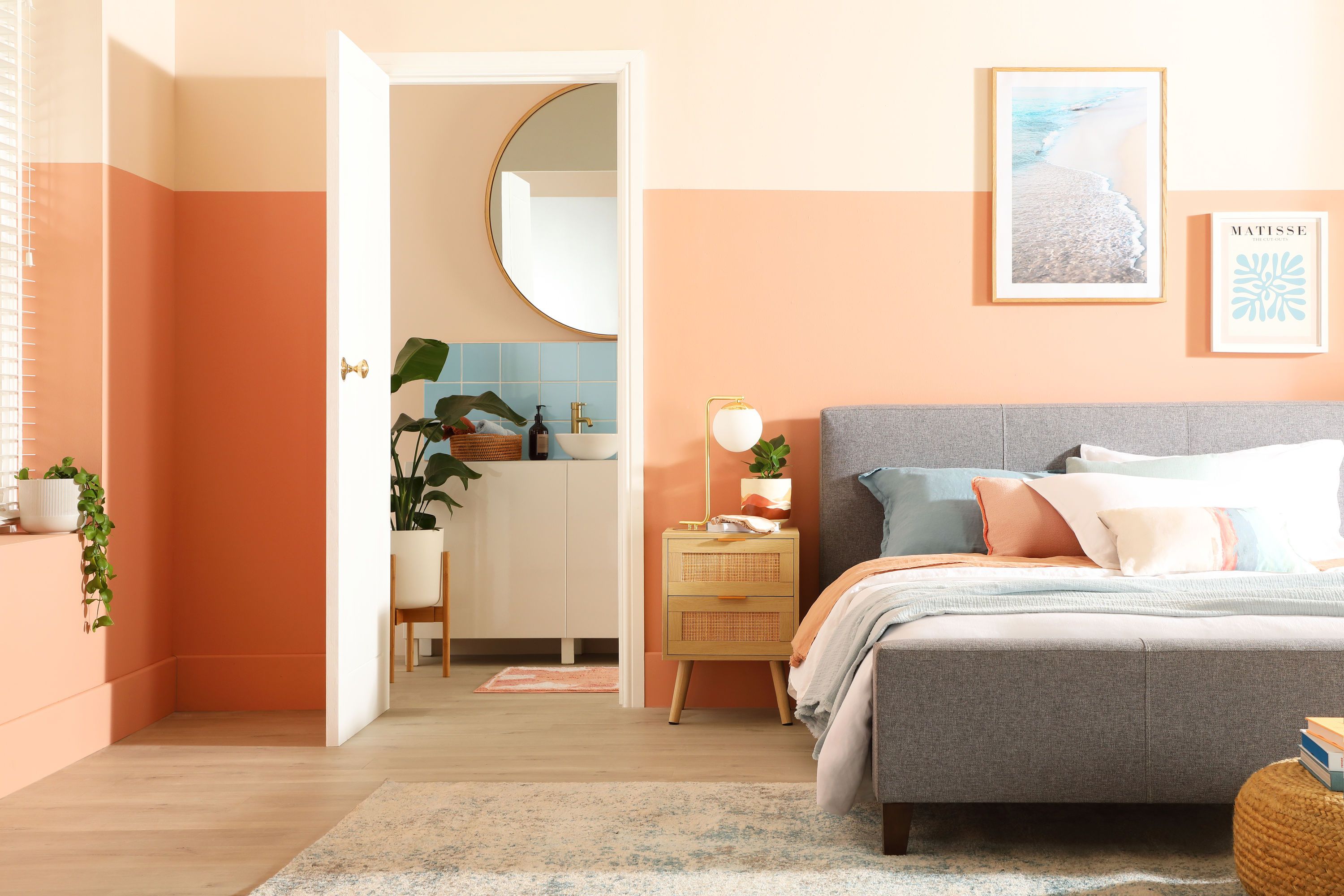Tropical bedroom with peach walls and grey fabric bed