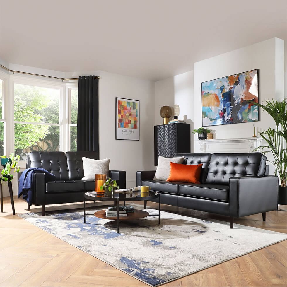 Black sofa set in white living room with jewel tone accessories