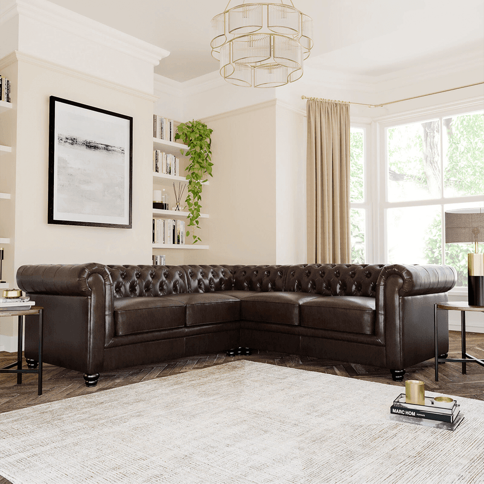 A brown leather Chesterfield sofa in an elegant beige and gold living room