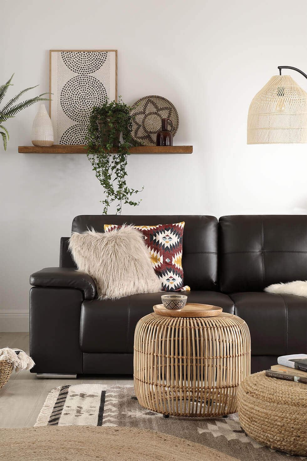 A brown leather sofa in a neutral modern boho living room