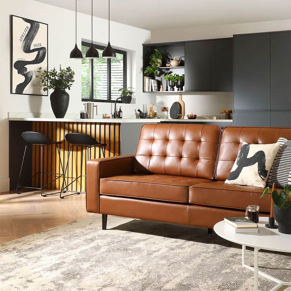 Stylish brown leather sofa in an open plan space with sleek black accents