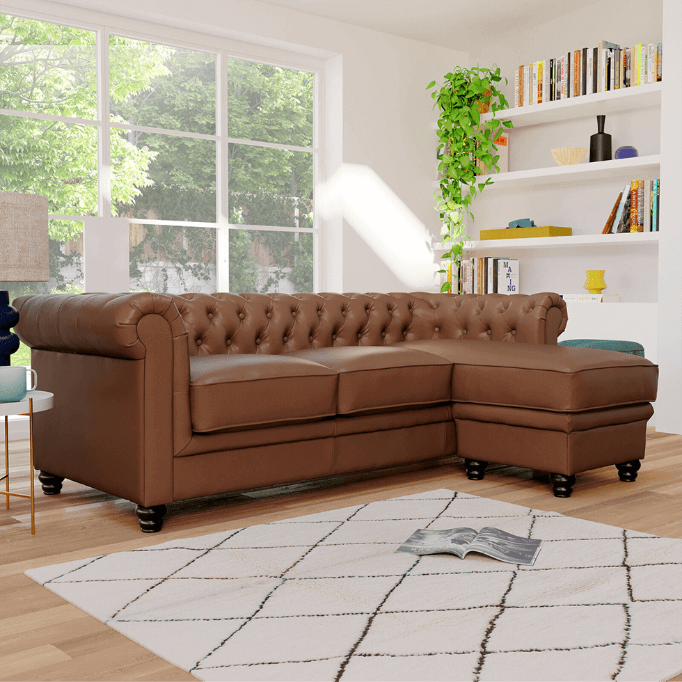 A stylish brown leather sofa in a Chesterfield design with yellow accessories and green accents