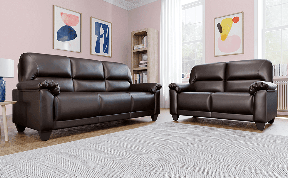 A dark brown sofa set in a living room with soft pink walls
