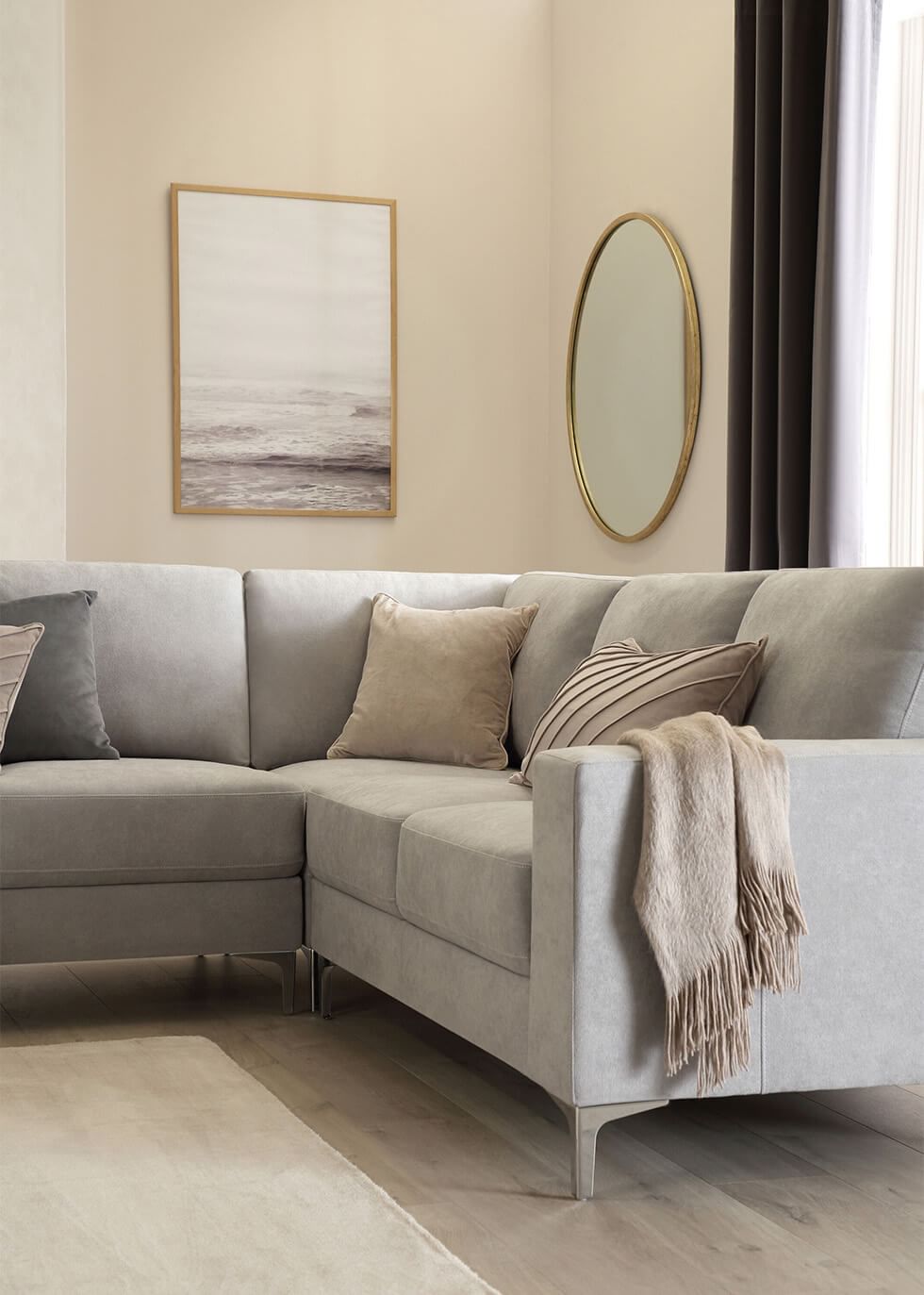 A plush grey sofa with neutral accessories and textures