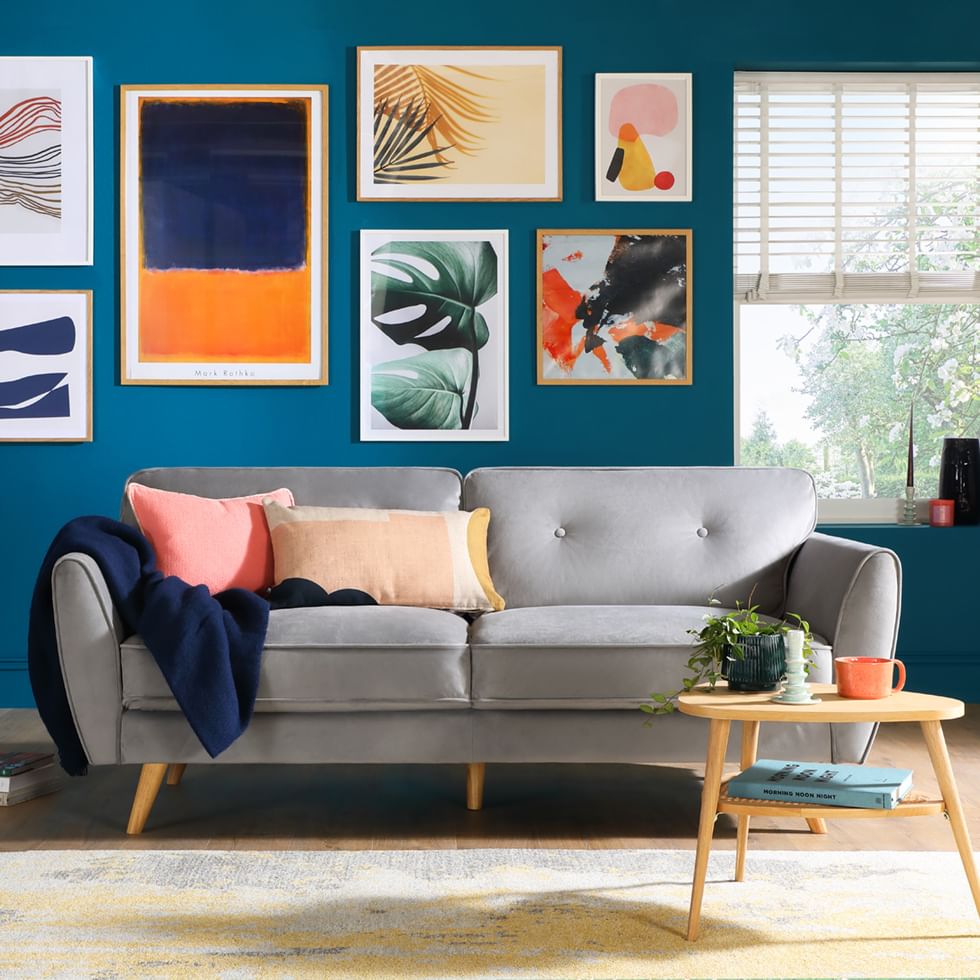 Bright and colourful living room with grey sofa and gallery wall