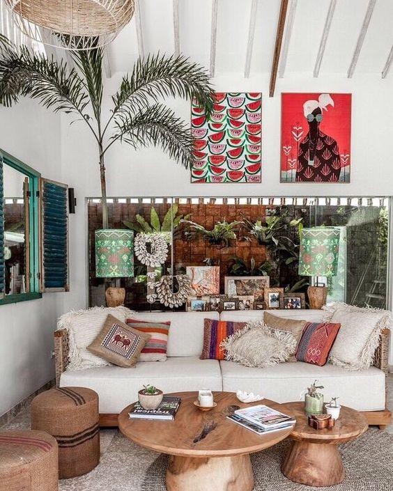 Balinese living room with wooden furniture, ikat cushions and colourful artwork.